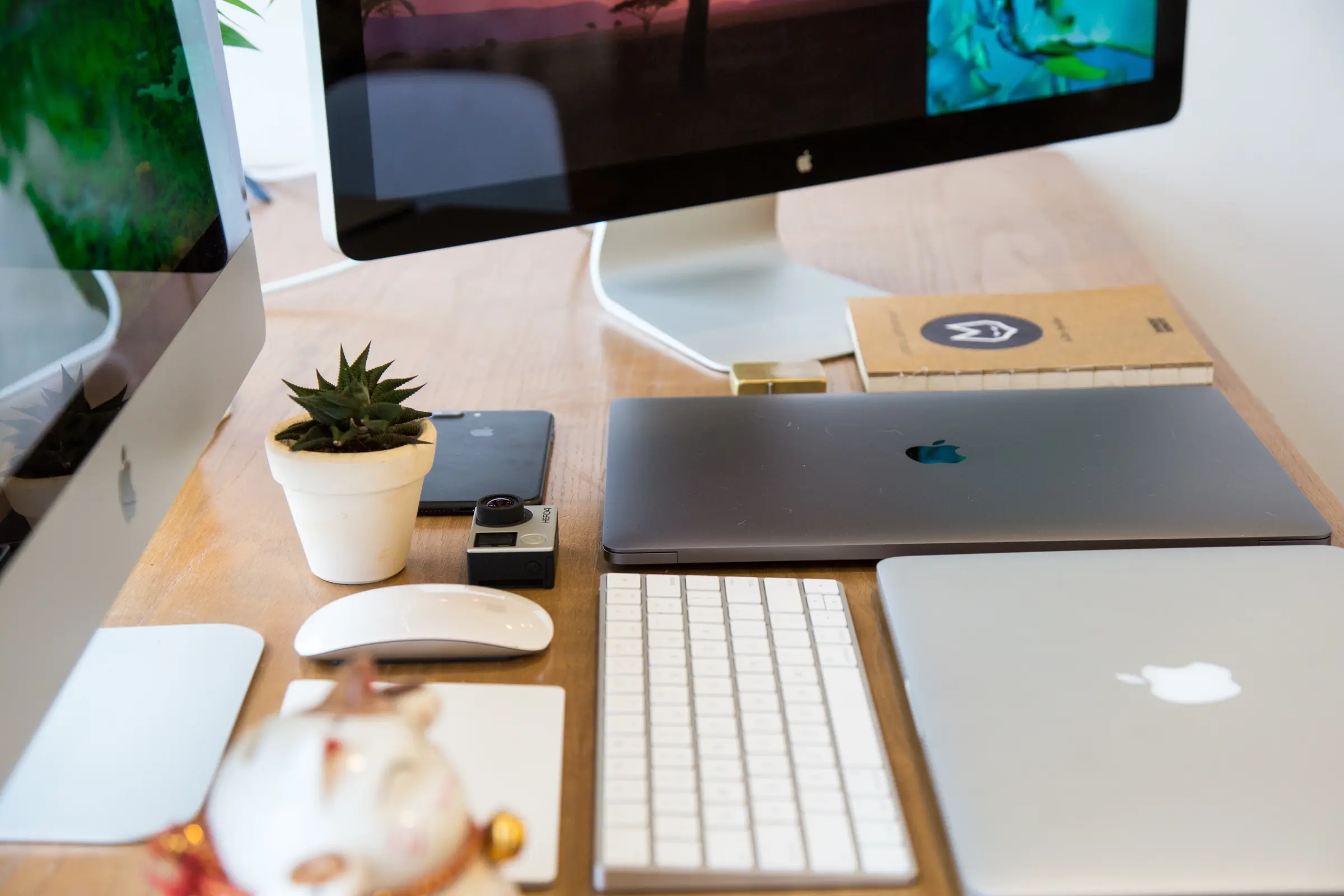 image of a desk with a computer, a wireless keyboard and mouse, 2 computers and some ornaments representing the graphic designer content creator job position featured image for gas leaks