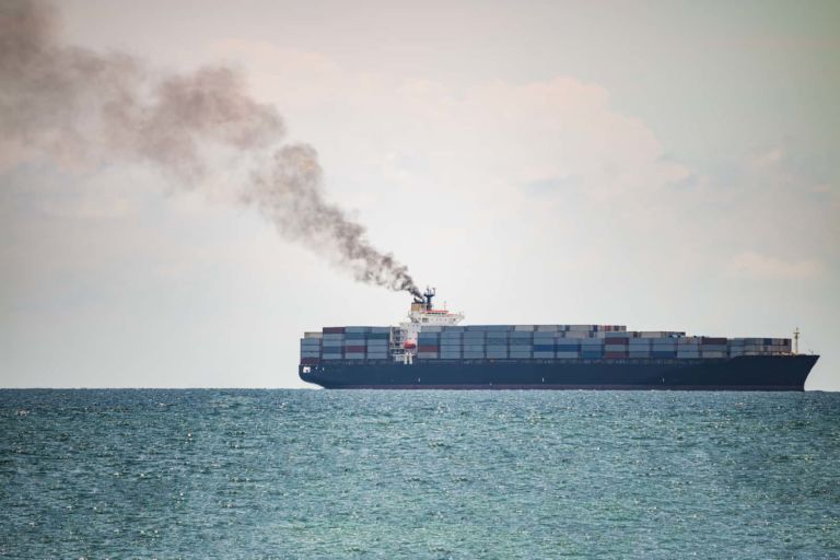 Container ships in the sea have a lot of black smoke